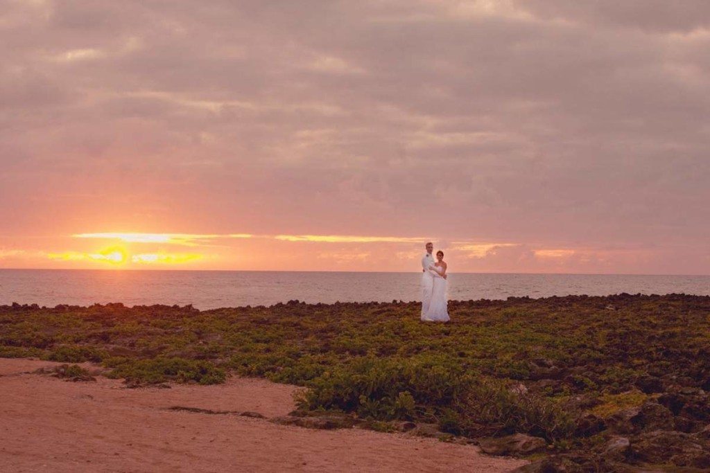 bride and groom on the beach at sunset in hawaii
