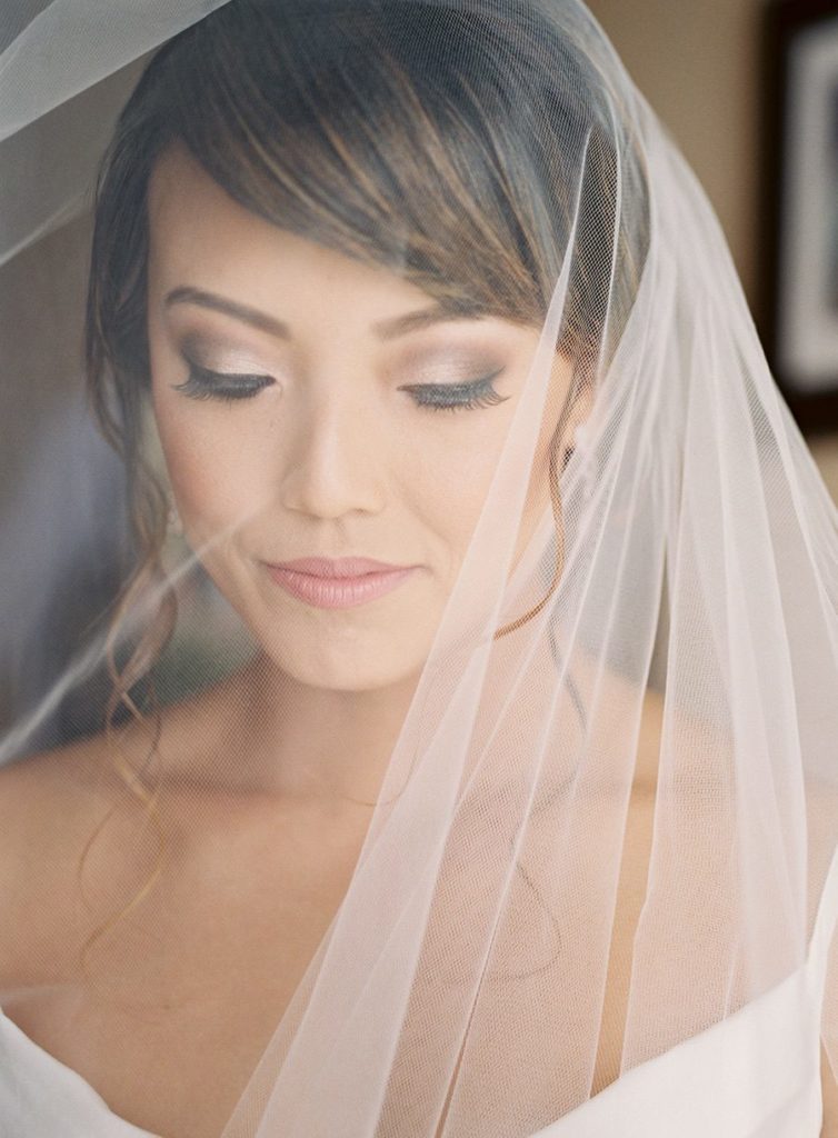 Bride with wedding veil over her face looking down. Destination wedding photographer
