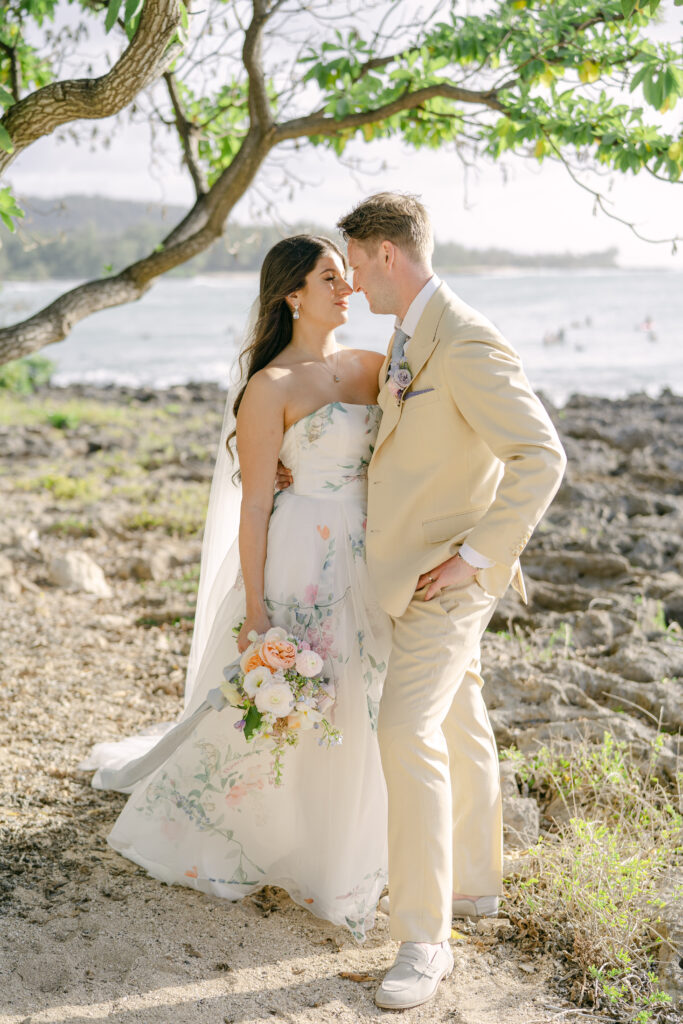a man and woman in wedding attire on the beach at Turtle Bay Resort in Hawaii