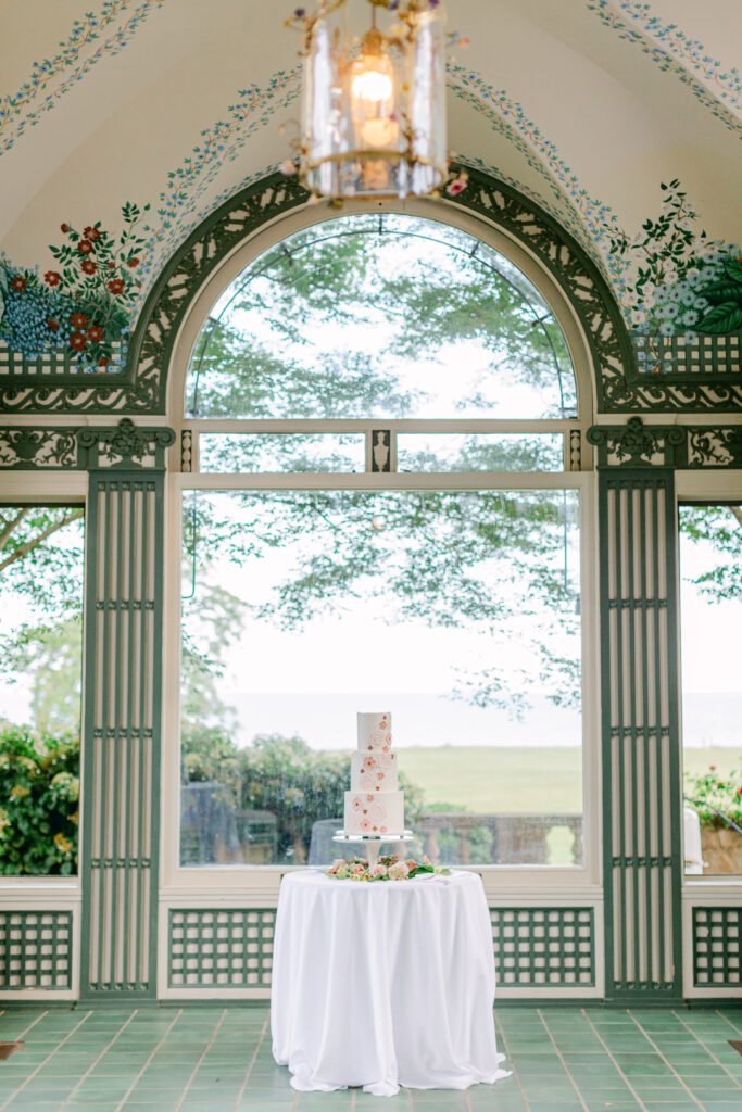 Eolia Mansion Breakfast room. Wedding cake as hero image under the archway. wedding cake is white with pink floral iced design. Harkness state park in waterford ct
