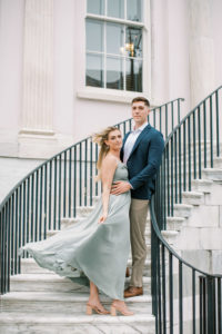Romantic couple posing for engagement photos on the steps of the federal court house Charleston South Carolina
