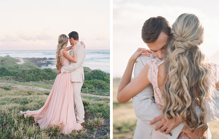 Bride in blush dress dancing with groom at sunset on the beach in Hawaii