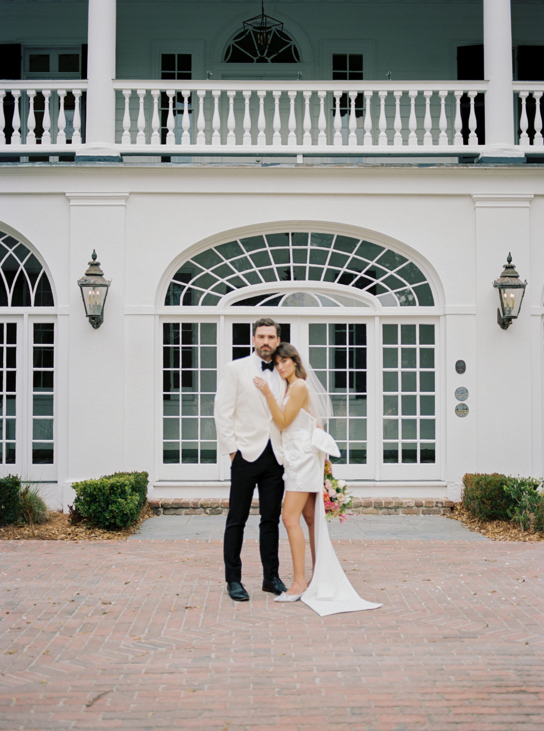 couple in an embrace in front of Lowndes Grove - Charleston Wedding venue