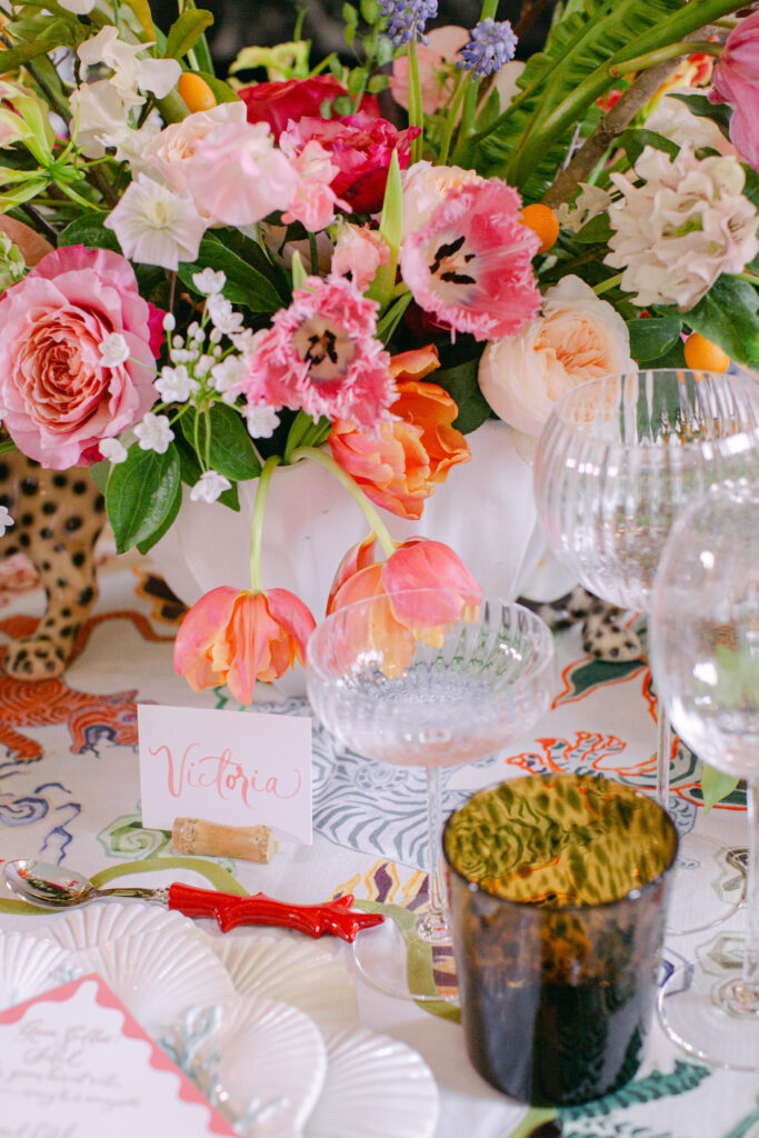 Close up table decor for a destination wedding. Roses and tulips in hot pinks, oranges with pops of pastels pinks and peaches. 