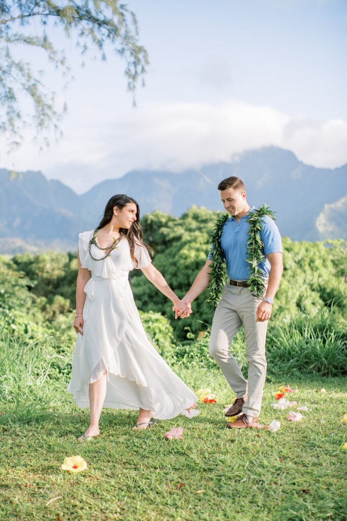 couple walking across lawn. Elope kauai hawaii