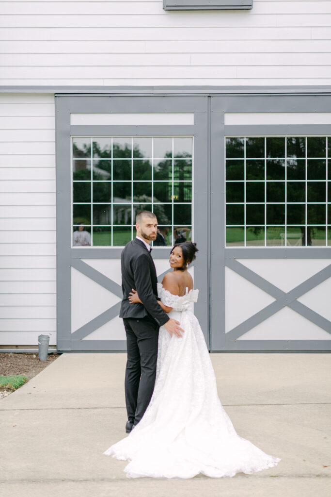 A Joyful Summer Wedding at a Private Estate in Raleigh, NC 11 a bride and groom looking back at the camera in raleigh north carolina