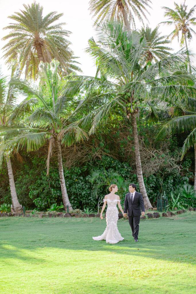 couple walking across lawn loulu palm estate oahu north shore